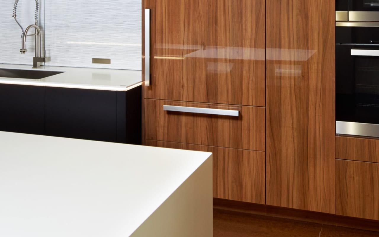 Closeup of glossy vertical grain wood cabinetry.