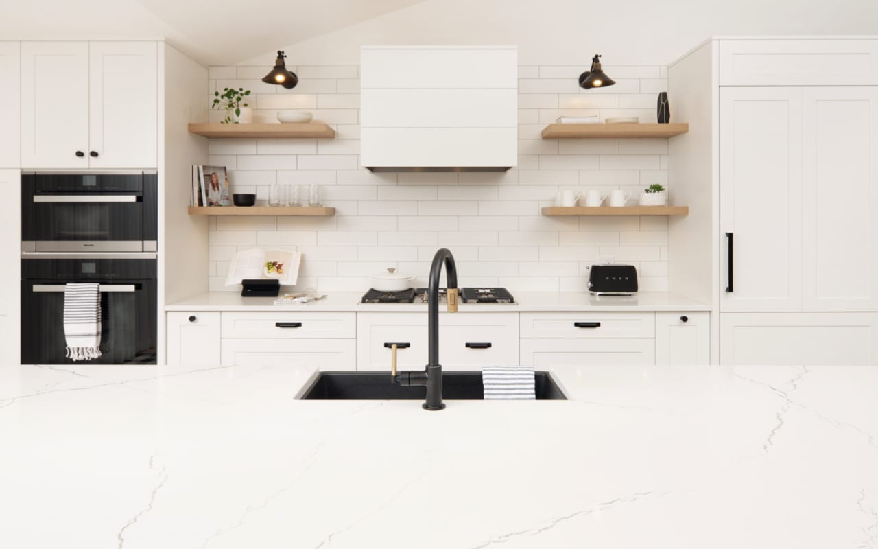 Modern farmhouse kitchen with white shaker-style cabinets and black hardware.