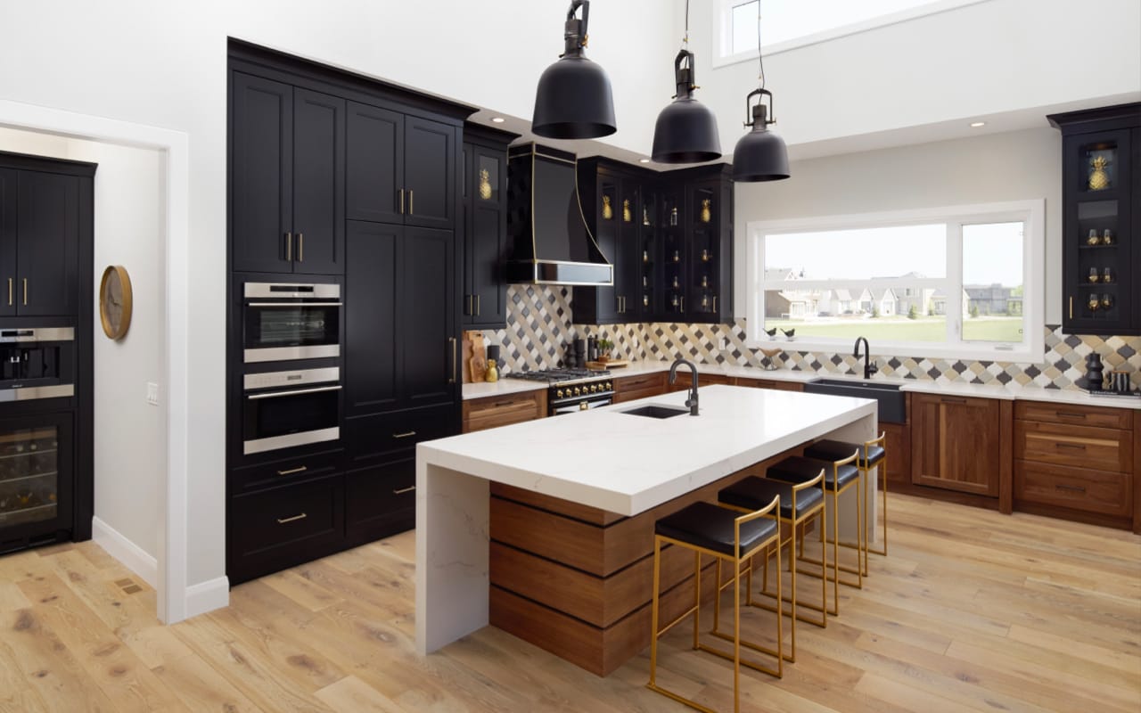 Transitional kitchen with black and walnut cabinetry and gold kitchen accessories.