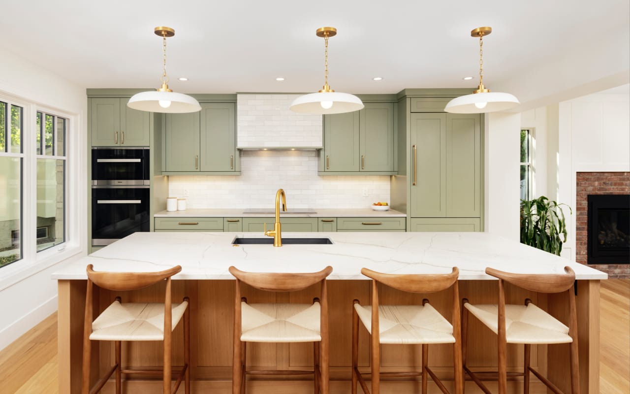 Transitional style kitchen with white shaker cabinets and walnut wood accents.