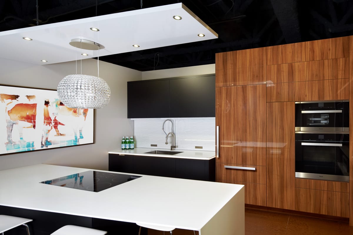Contemporary kitchen with sleek details including a paneled refrigerator and island with a waterfall countertop.