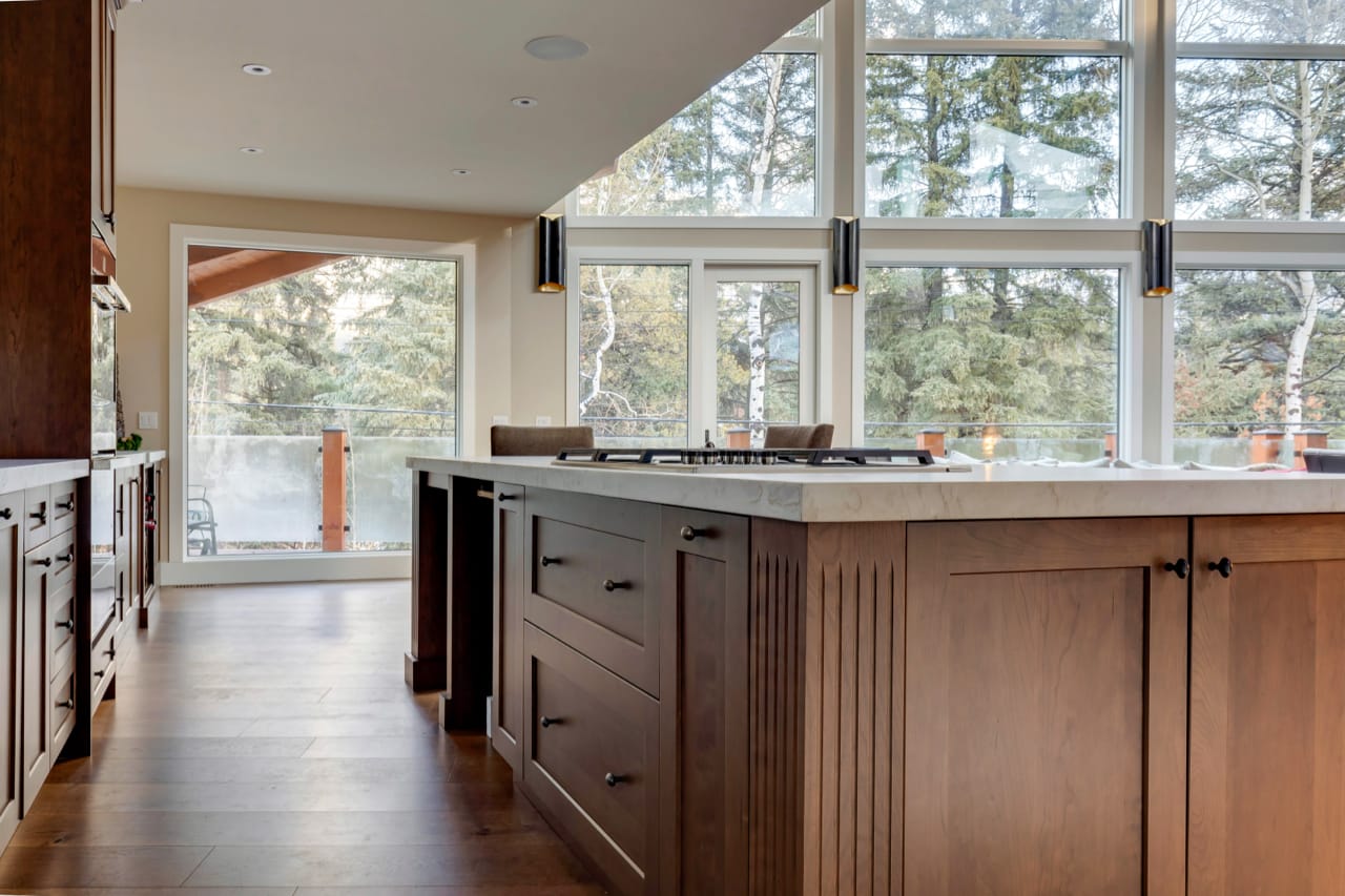 Closeup of a kitchen island with corner detailing and lush forest in the background.