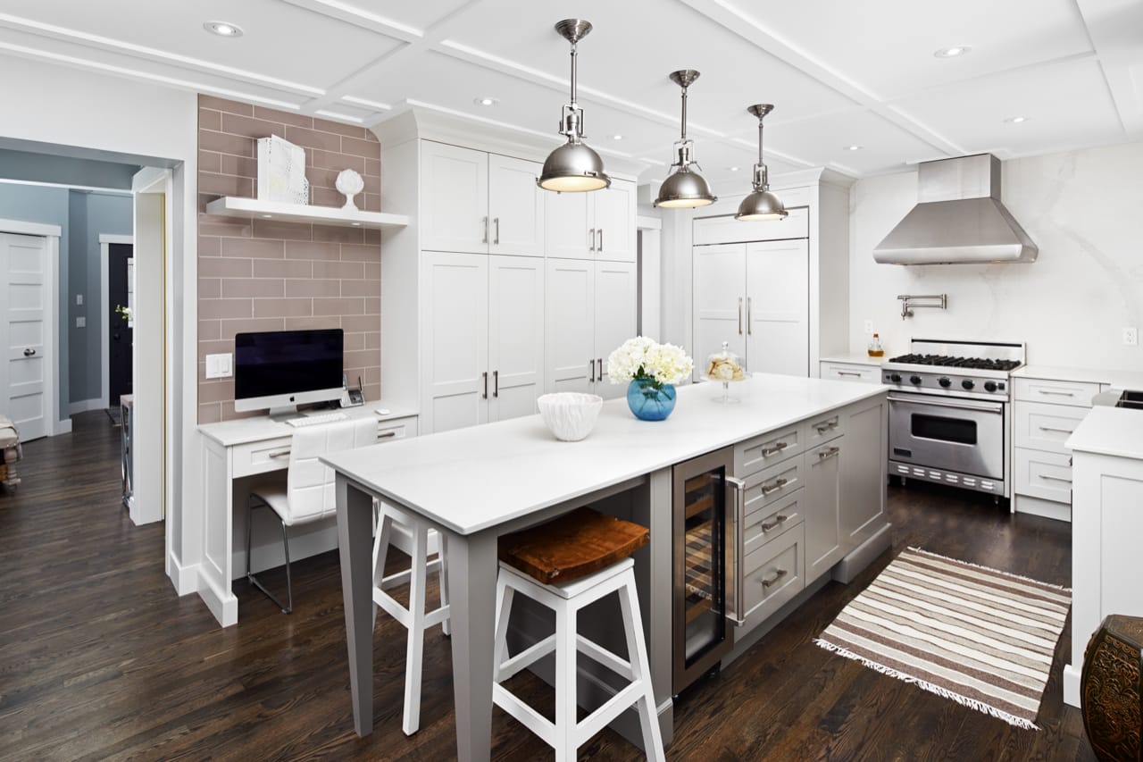 Oversized island with bar fridge and seating. A dedicated computer desk is located on the left hand side of the kitchen.