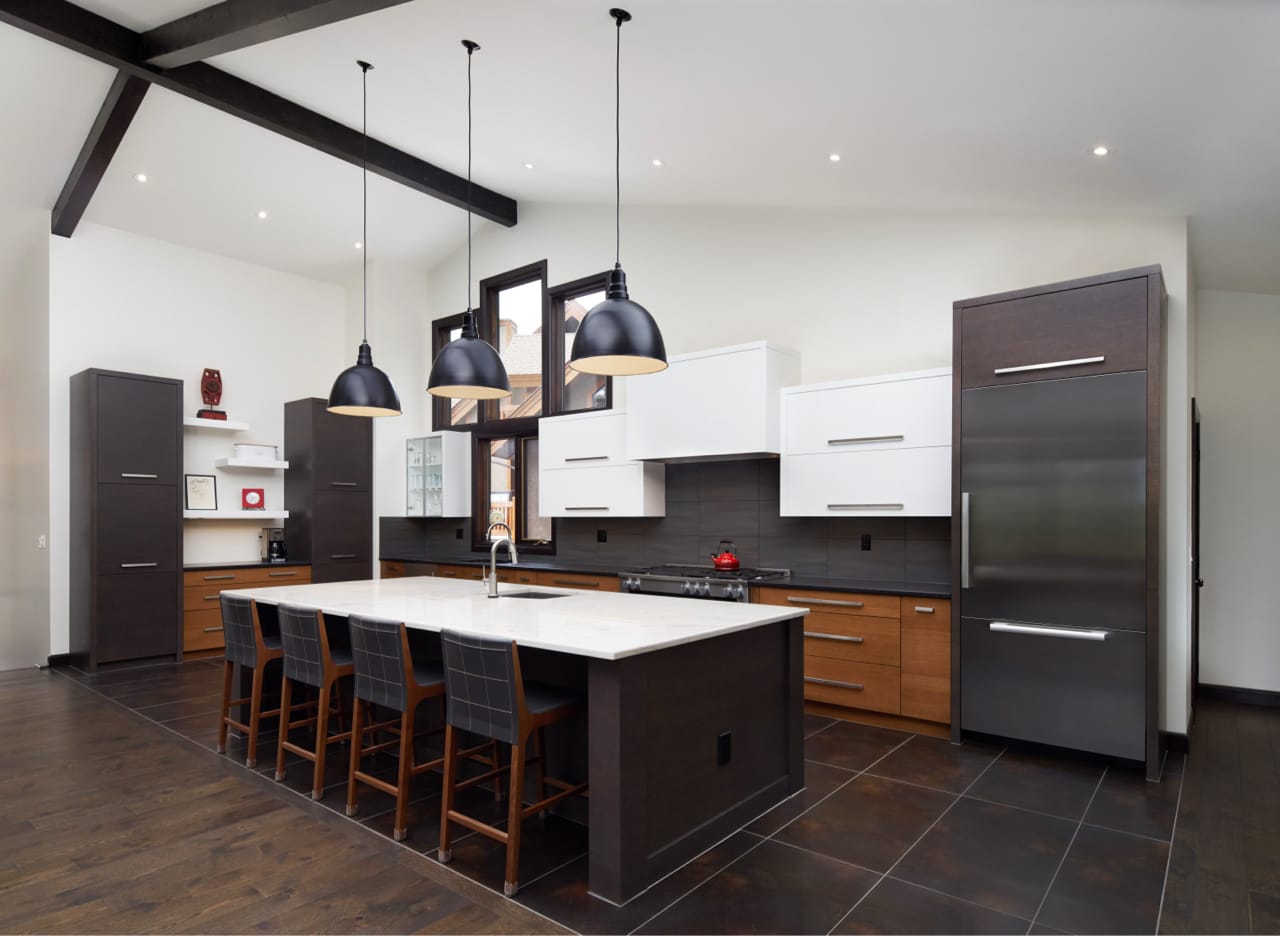 Ceiling beams with a grey stain to match the kitchen cabinets highlight the attention to detail in this renovation.