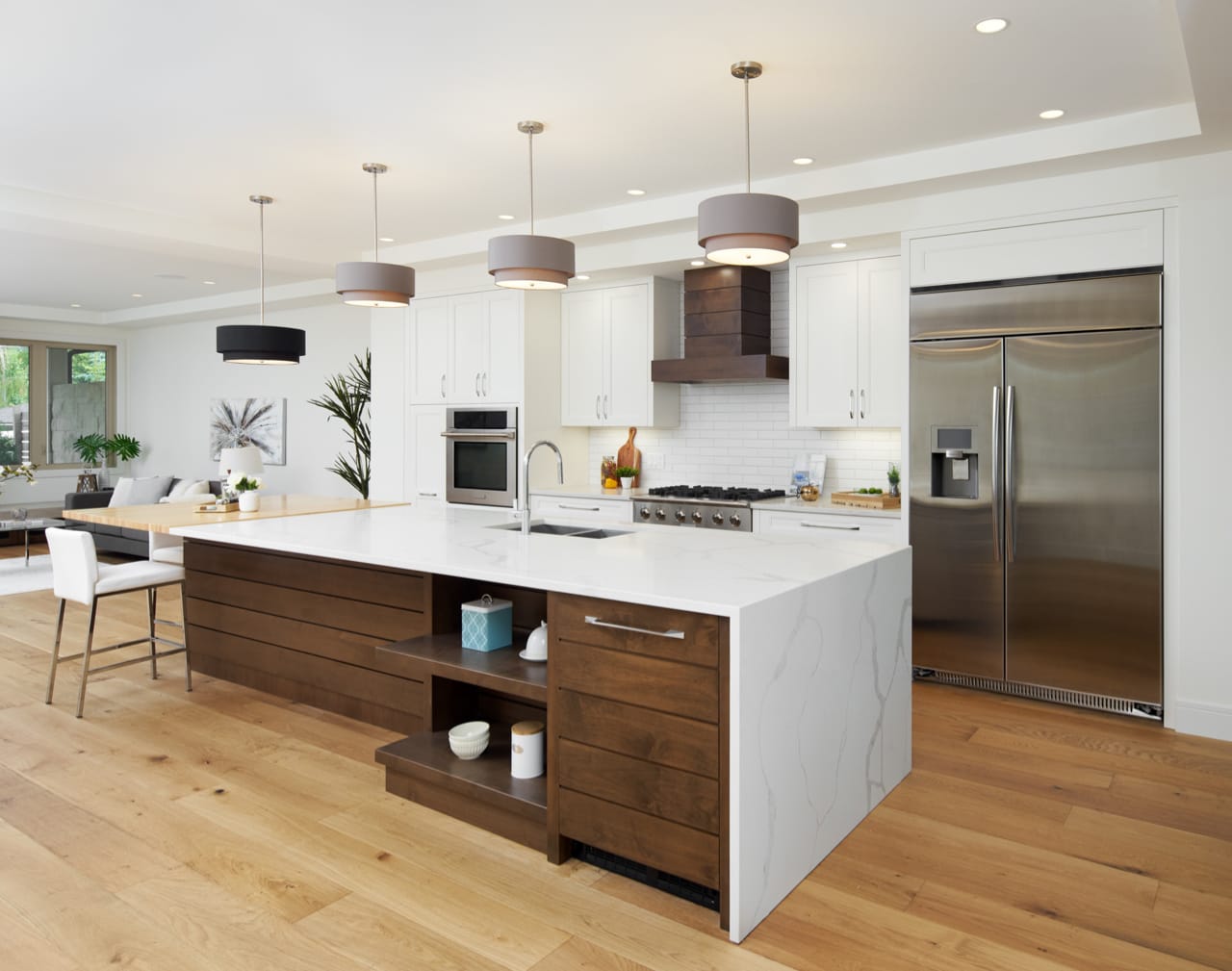 Transistional kitchen with oversized island with shiplap detailing and a white waterfall countertop.