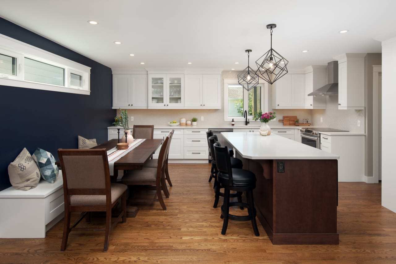 Two tone white and walnut cabinet with breakfast bar and bench seating.