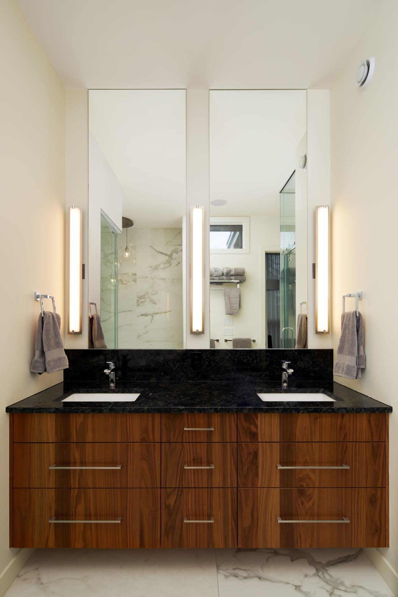 Matching the kitchen, the main floor bath includes a matching vanity in the same vertical grain walnut cabinetry.