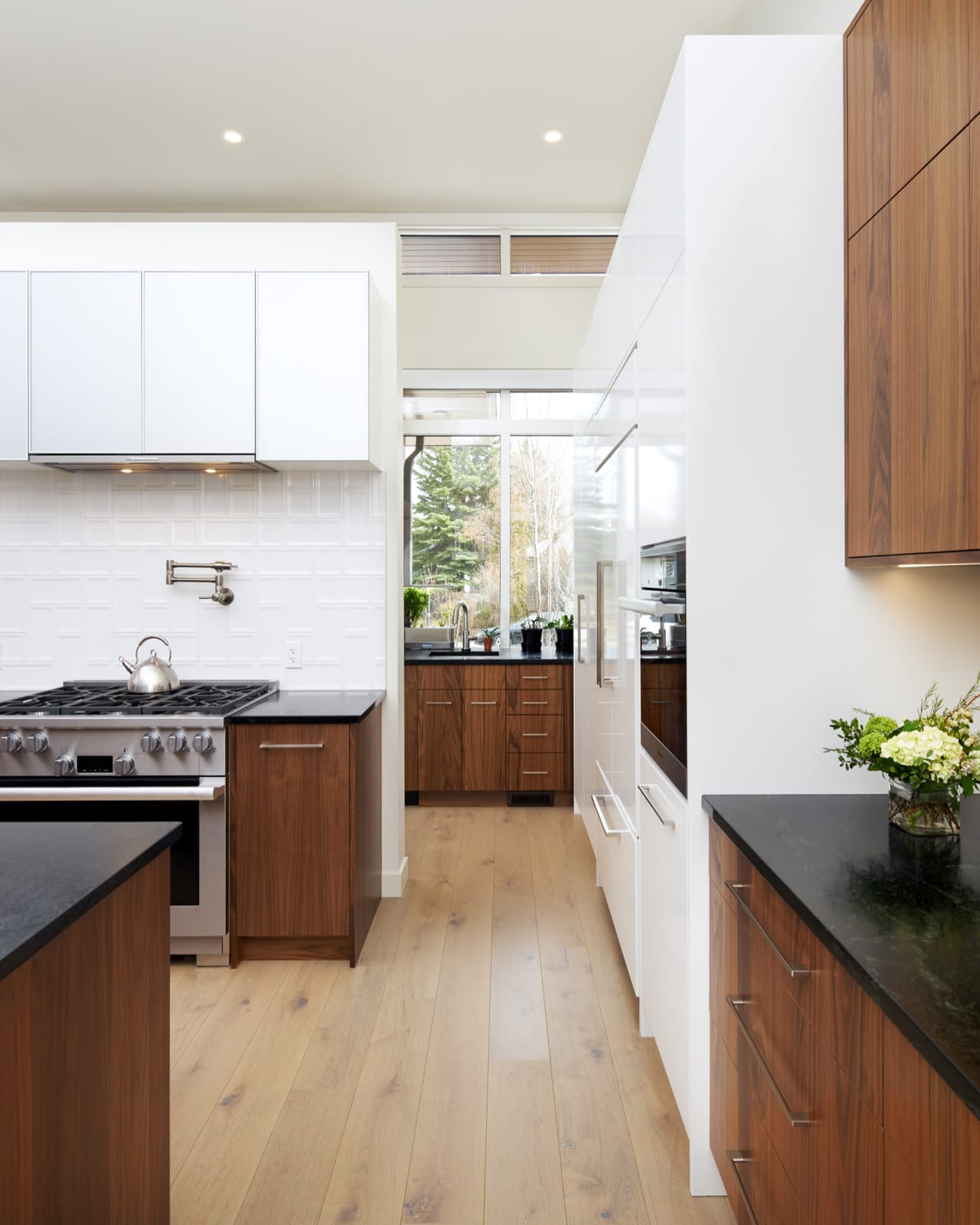 Black countertops and simple hardware add to the minimalist design of this kitchen.